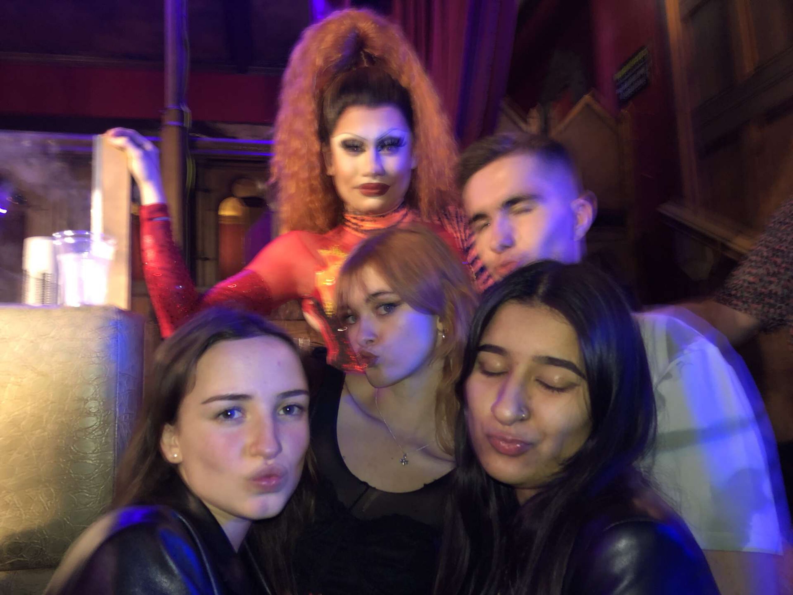 Four students posing alongside a drag queen in the gay bar, Rusty's