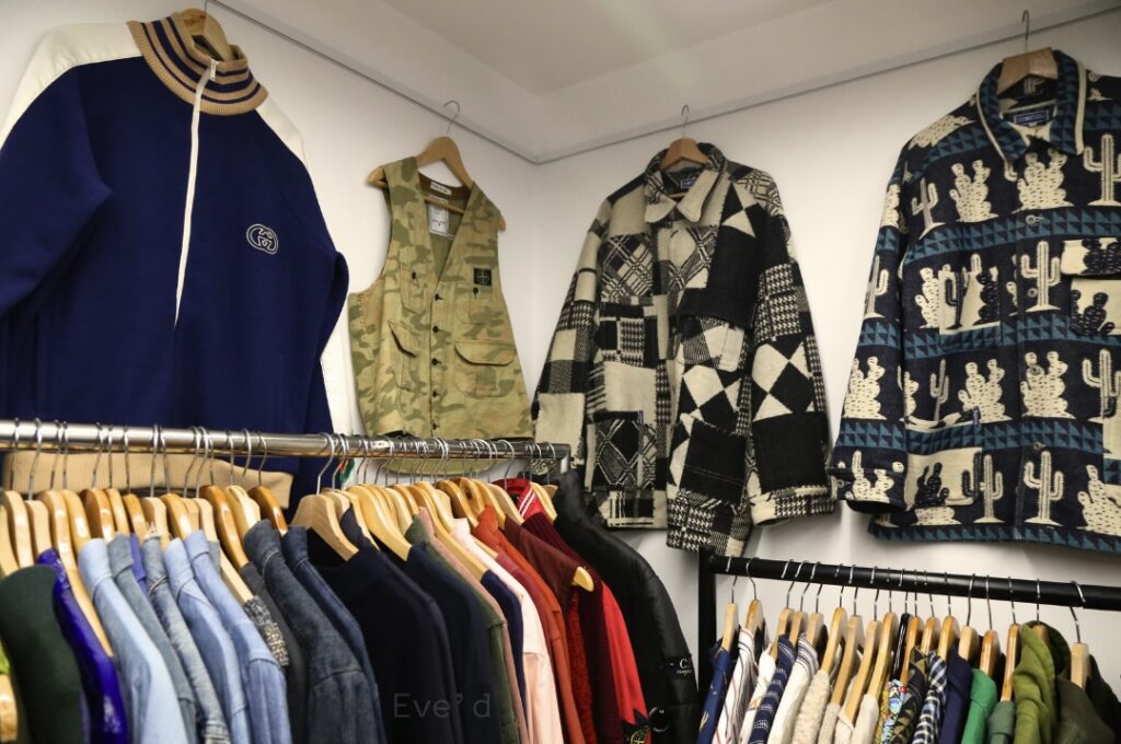 Image of the menswear selection, three jackets displayed on the wall, rail of colourful jackets